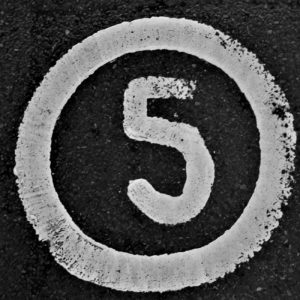 The number 5 written on a road in white paint and circled.