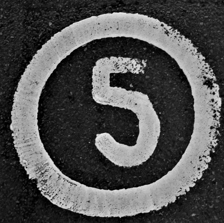 The number 5 written on a road in white paint and circled.