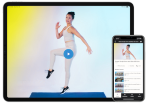 Tablet and phone screen showing video thumbnail of a woman doing a barre workout.